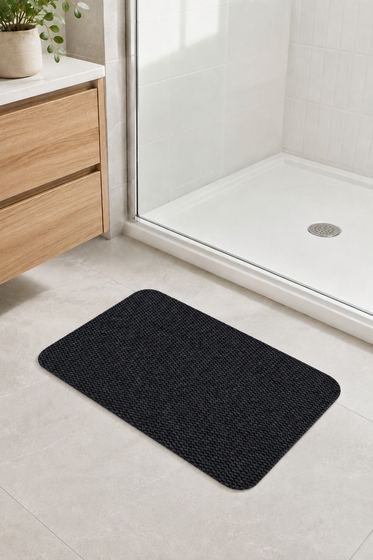 Duş önüne serilmiş siyah banyo paspası